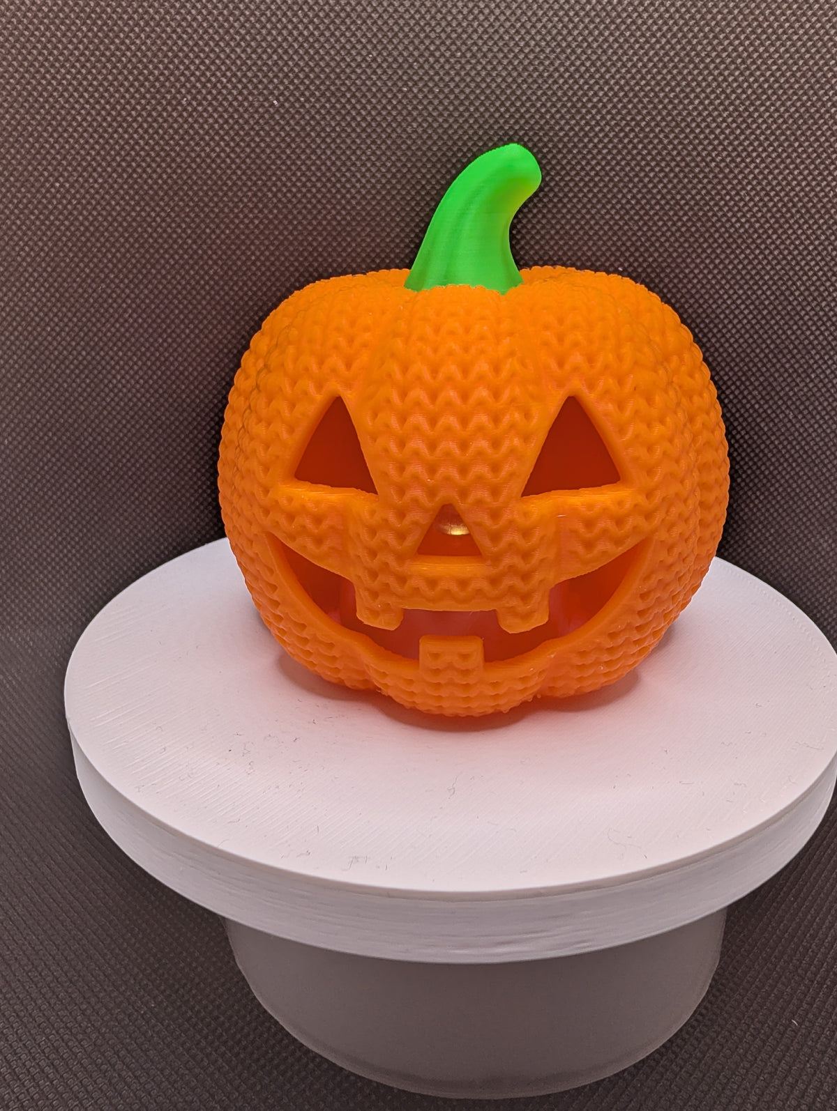 Orange knitted-style pumpkin LED tealight holder with a green stem