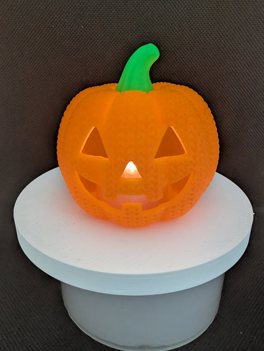 Orange knitted-style pumpkin LED tealight holder with a green stem