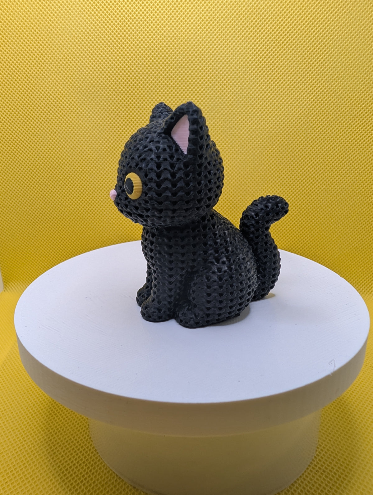 Side view of black cat figurine showing raised tail