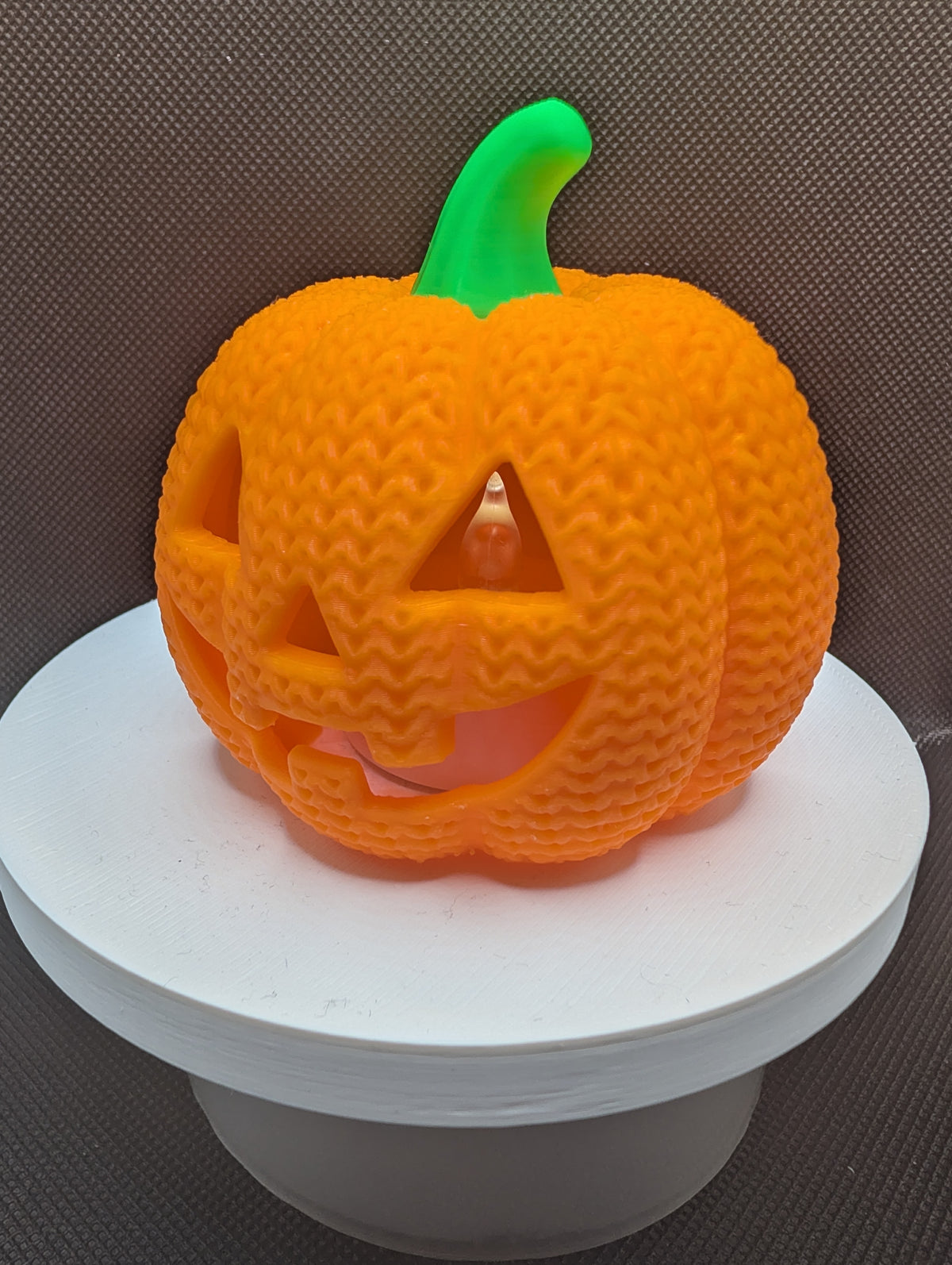 Orange pumpkin LED tealight holder, angled view